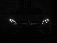 the front lights of a mercedes car are glowing in the dark