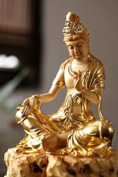 a golden buddha statue sitting on top of a table