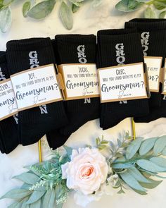 four pairs of socks with wedding date tags on them and flowers in front of them