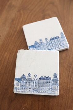 two blue and white coasters sitting on top of a wooden table