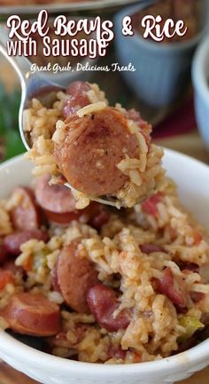 red beans and rice with sausage in a white bowl on top of a wooden table