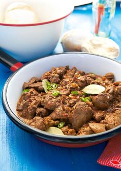 a close up of a bowl of food on a table with other foods and utensils