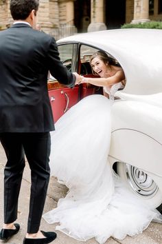 a bride and groom getting out of a classic car