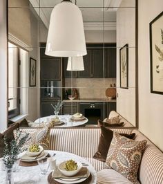 a living room filled with furniture next to a kitchen and dining room table in front of a mirror