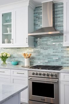 a stove top oven sitting inside of a kitchen next to white cabinets and counter tops