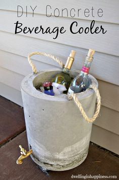 a concrete bucket filled with wine bottles on the side of a house that says diy concrete beverage cooler