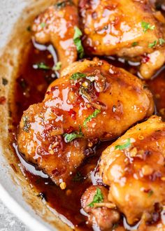 chicken wings with sauce and parsley in a white bowl