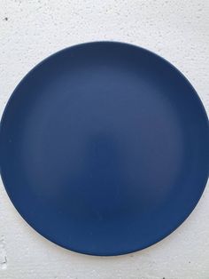 a blue plate sitting on top of a white wall