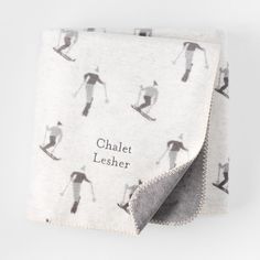 a blanket with skiers on it and the words chalet leher printed on it