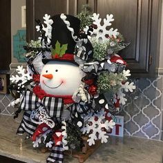 a snowman wreath on top of a kitchen counter