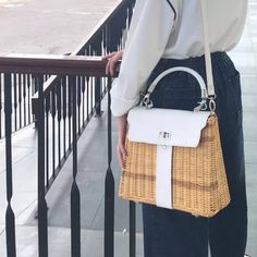 a woman is standing on the balcony with her handbag in front of her back