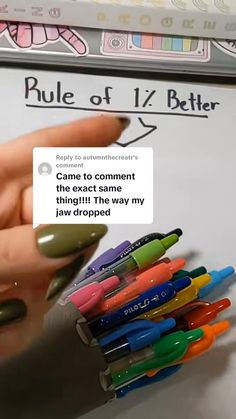 a pile of pens sitting next to each other on top of a whiteboard covered in writing