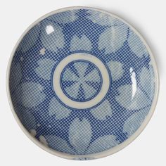 a blue and white porcelain bowl with an interlocked design on the outside, in front of a white background