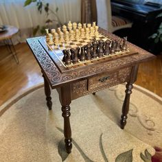 a wooden chess set sitting on top of a table in a living room next to a couch