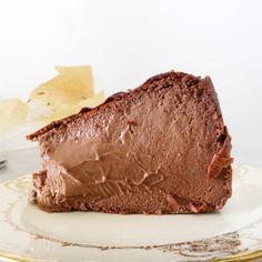 a piece of chocolate cake sitting on top of a white plate next to some chips