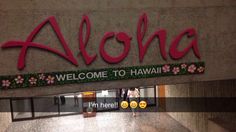 the welcome sign to aloha is decorated with pink flowers and green foliages