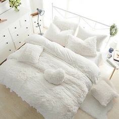 the bed is made with white fluffy blankets