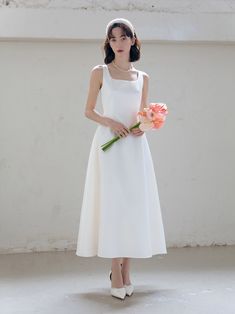 a woman in a white dress holding flowers