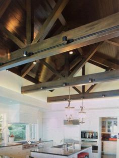 a kitchen with an island and wooden beams