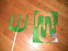 a green cake topper sitting on top of a wooden table