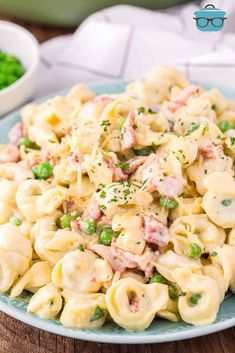 a close up of a plate of pasta with peas and ham on it next to broccoli