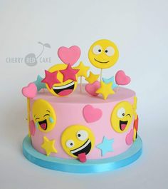 a pink cake decorated with smiley faces and stars