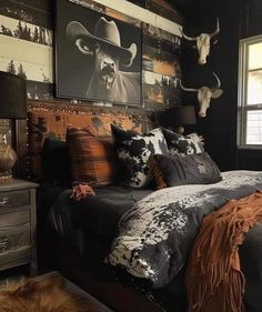 a bed room with a neatly made bed and cow heads on the wall above it