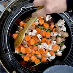 someone is cooking vegetables on the grill with a wooden spatula in their hand and they are about to be cooked