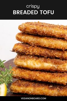 fried tofu sticks stacked on top of each other with lemon wedges in the background