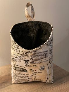 an old newspaper bag sitting on top of a wooden table next to a white wall