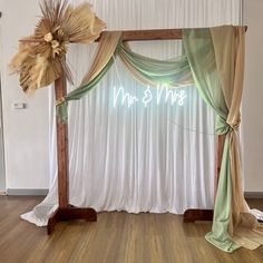 a wedding arch with the word mr and mrs written on it in front of a white backdrop