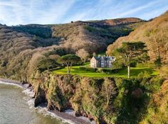 an aerial view of a large house on the edge of a cliff overlooking the ocean