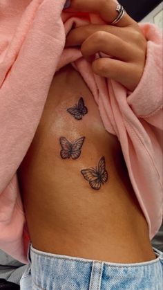 a woman's stomach with three butterflies on her side and the bottom part of her belly