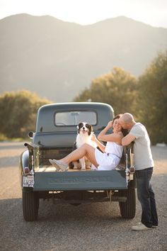 a man and woman kissing in the back of an old truck