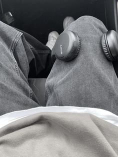 two people with headphones laying in the back of a car