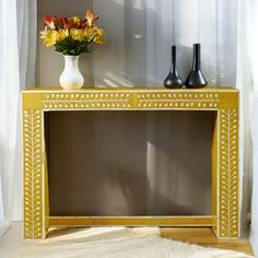 a vase with flowers sitting on top of a yellow table