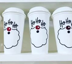 three white cups with red noses and the words ho ho ho on them are lined up next to each other