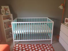 a baby's room with a crib, dresser and bookshelf in it