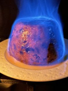 a cake with blue flames coming out of it's top on a white plate