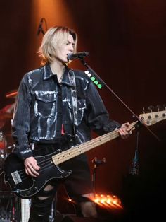 a man standing on stage with a guitar