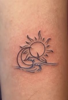 a small sun and wave tattoo on the leg