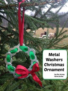 metal washers christmas ornament hanging from a tree with sheep in the background