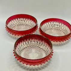 three red glass dishes sitting next to each other