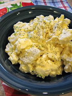 a blue plate topped with scrambled eggs on top of a table