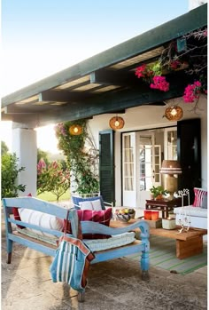 an outdoor patio with furniture and flowers hanging from the roof