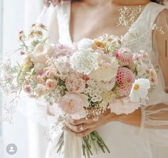 a woman holding a bouquet of flowers in her hands