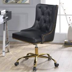 a black office chair with gold studding on the armrests and casteors