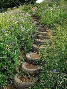 a set of steps made out of tires in the middle of some grass and flowers