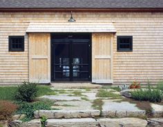 an outside view of a house with stone steps leading to the front door and windows