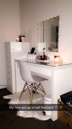 an image of a vanity with lights on the mirror and chair in front of it